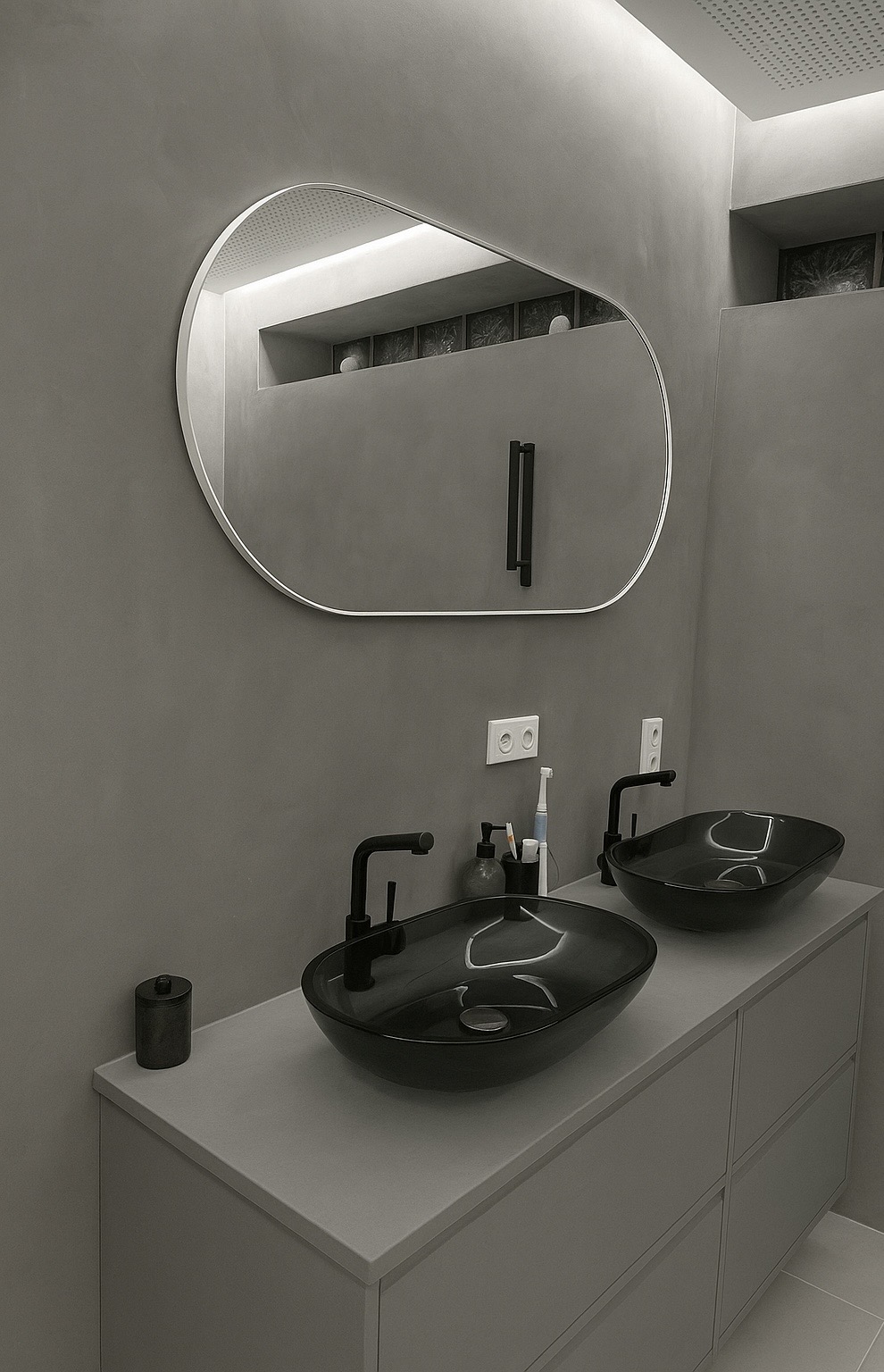 Modernes Badezimmer mit fugenlosem Mikrozement in Grau und zwei schwarzen Aufsatzwaschbecken
