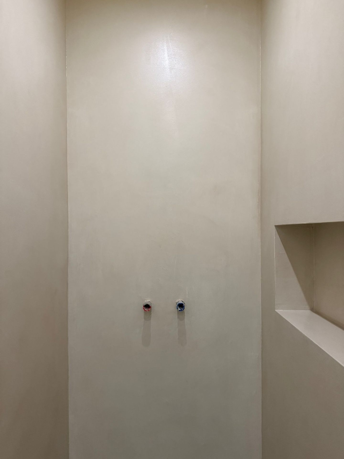 Fugenlose Mikrozement-Duschwand in Creme-Beige mit integrierter Wandnische