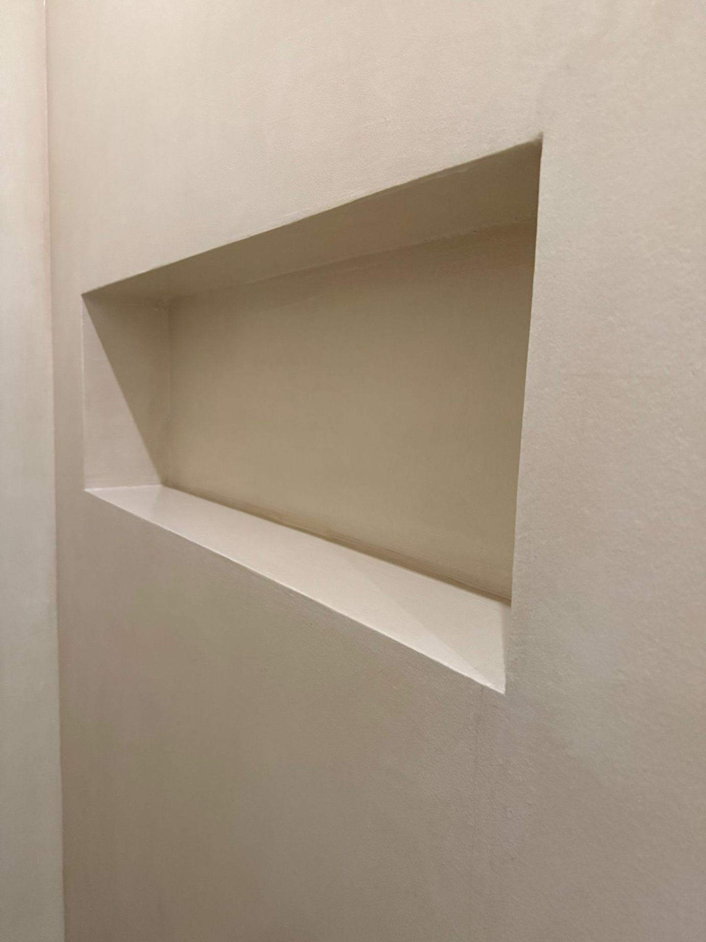 Mikrozement-Wandnische in Creme-Beige als Detailaufnahme mit eingelassener Ablagefläche
