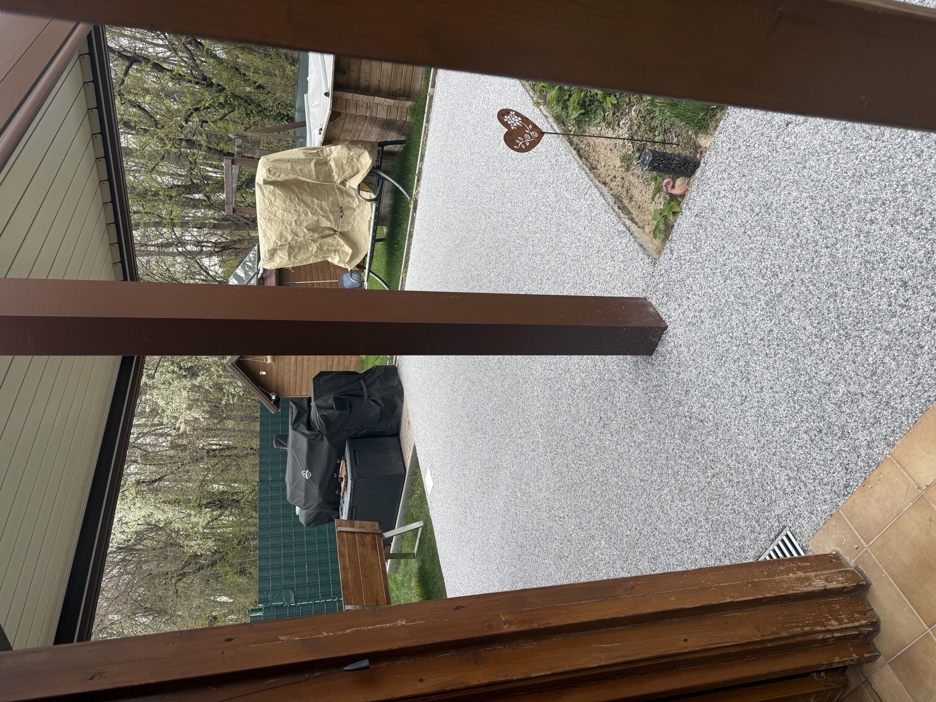 Terrasse mit Natursteinteppich Bodenbeschichtung in Grau, Blick von Pergola auf Garten